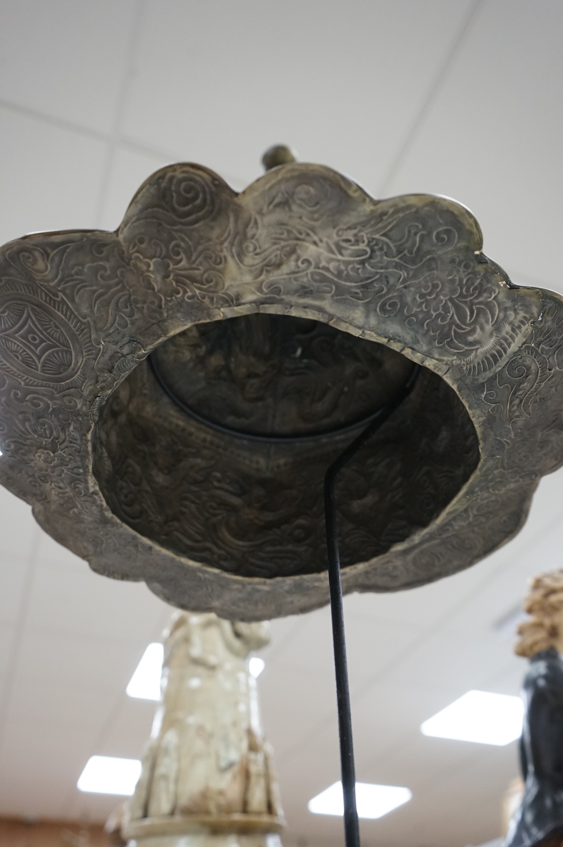 A Chinese Miao tribe embossed metal ceremonial headdress on stand, 63cm high